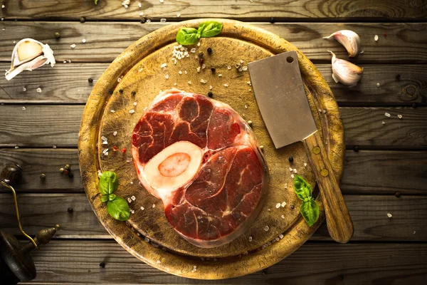Ham taze sarımsak, biber ve baharat kasap cleaver ile ahşap kesme tahtası üzerinde ile kesilmiş Dana çapraz. 