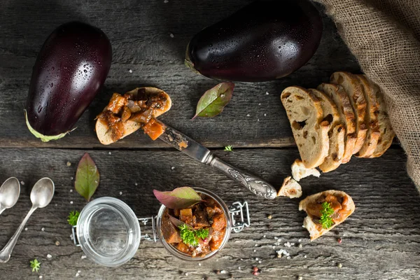 Eggplant caviar in glass jar with ciabatta, punch and basil. Eggplant Dip