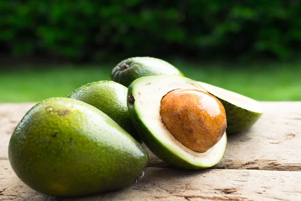 fresh avocado and slices avocado on old wooden background