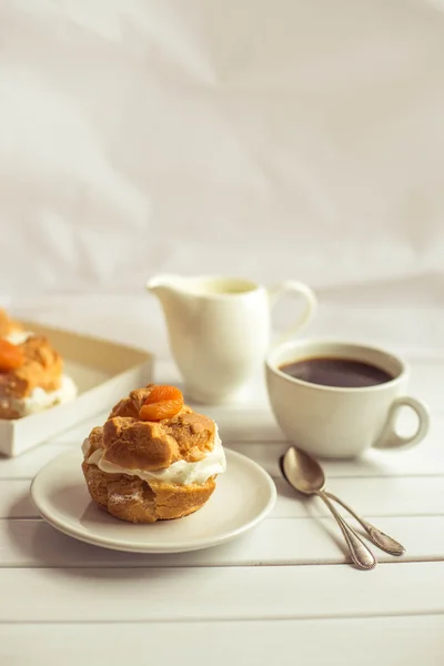 Puff de creme fresco caseiro com chantilly e damascos, xícara de café e jarro de leite . — Fotografia de Stock