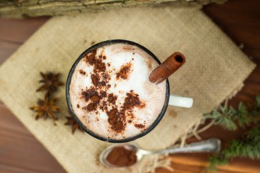 Vintage bir fincan sıcak çikolata tarçın ile rustik arka plan üzerinde sopa. Üstten Görünüm.