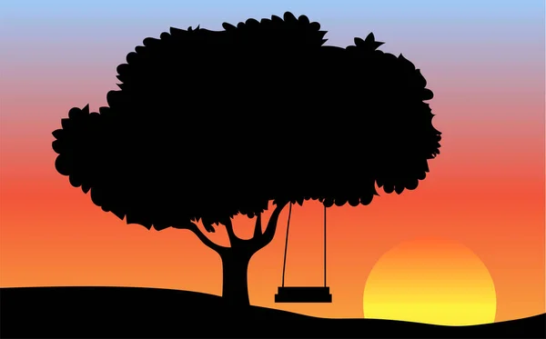 Gün batımında büyük ağaç ve salıncak