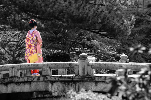 Zwart-wit van een brug in Kyoto met selectieve kleur op een jonge vrouw van Geisha — Stockfoto