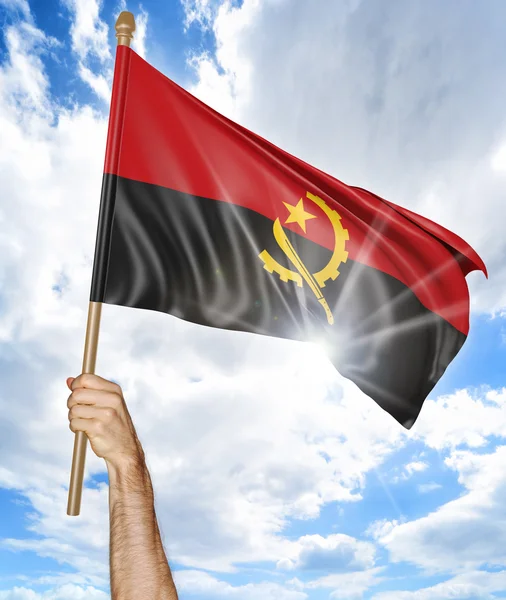 A mão da pessoa segurando a bandeira nacional angolana e acenando-a no céu, renderizando 3D — Fotografia de Stock