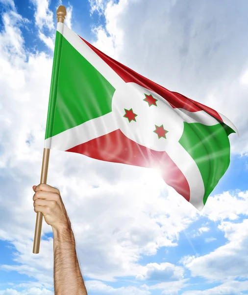Iemands hand houden van de nationale vlag van Burundi en het zwaaien in de lucht, onderdeel 3D-rendering — Stockfoto