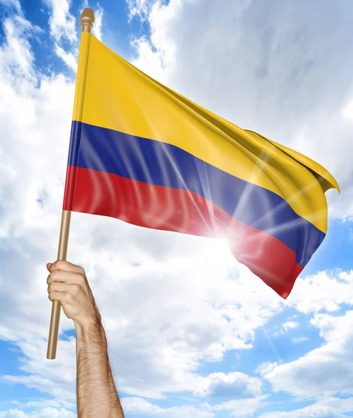 Iemands hand houden van de Colombiaanse nationale vlag en het zwaaien in de lucht, onderdeel 3D-rendering — Stockfoto