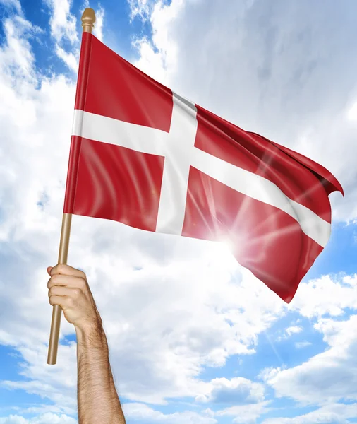 A mão da pessoa segurando a bandeira nacional dinamarquesa e agitando-a no céu, renderização 3D — Fotografia de Stock