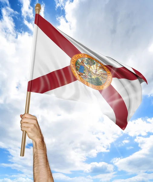 Person 's hand holding the Florida state flag and waving it in the sky, 3D rendering — стоковое фото