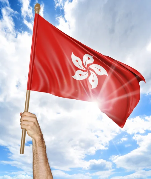 Mano de la persona sosteniendo la bandera nacional de Hong Kong y agitándola en el cielo, representación 3D —  Fotos de Stock