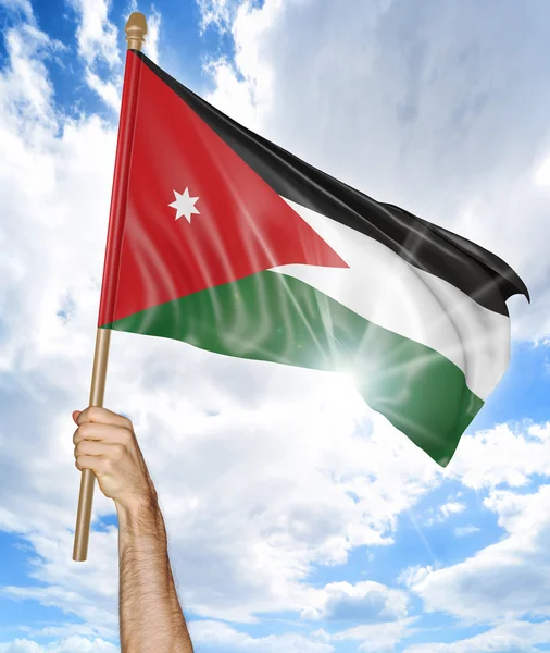 Person 's hand holding the Jordanian national flag and waving it in the sky, 3D rendering — стоковое фото