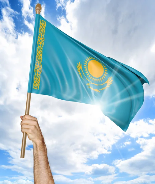 Persons hand hålla Kazakstan landets flagga och vifta det i himlen, 3d-rendering — Stockfoto