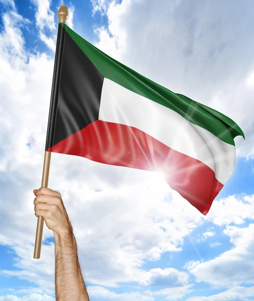 Рука человека, держащая государственный флаг Кувейта и размахивая им в небе, 3D рендеринг — стоковое фото