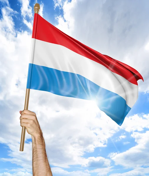 Person's hand holding the Luxembourg national flag and waving it in the sky, 3D rendering — Stock Photo, Image