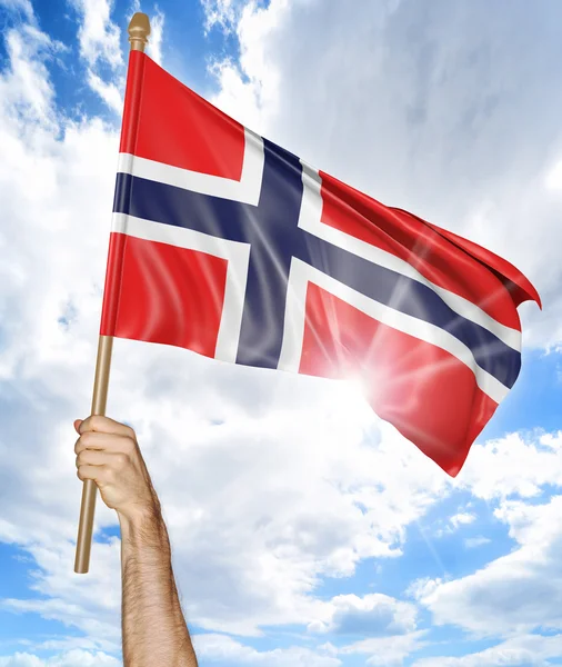 Mano de la persona sosteniendo la bandera nacional noruega y agitándola en el cielo, representación 3D — Foto de Stock