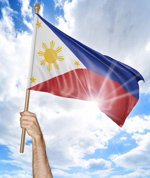 Person 's hand holding the Philippines national flag and waving it in the sky, 3D rendering — стоковое фото