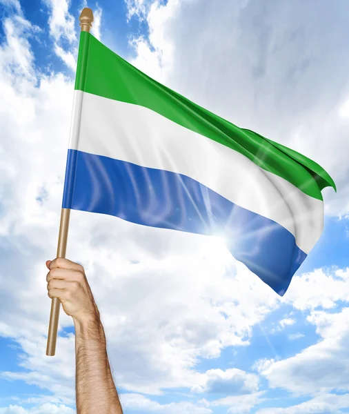 Persons hand hålla Sierra Leone landets flagga och vifta det i himlen, 3d-rendering — Stockfoto