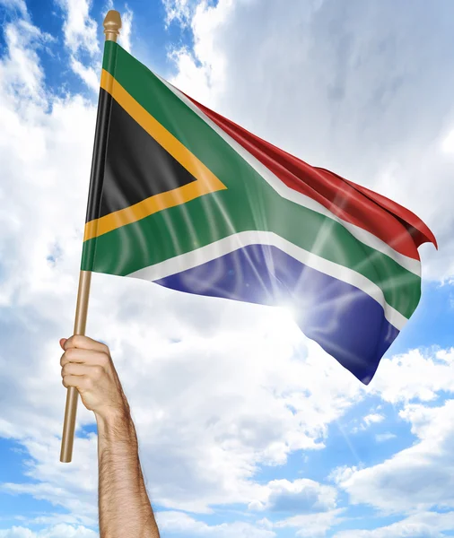 Mão de pessoa segurando a bandeira nacional sul-africana e acenando-a no céu, renderização 3D — Fotografia de Stock