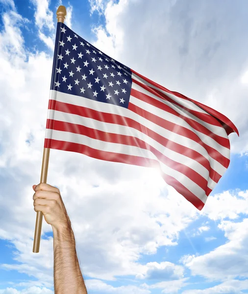 Mano de la persona sosteniendo la bandera nacional estadounidense y agitándola en el cielo, representación 3D — Foto de Stock