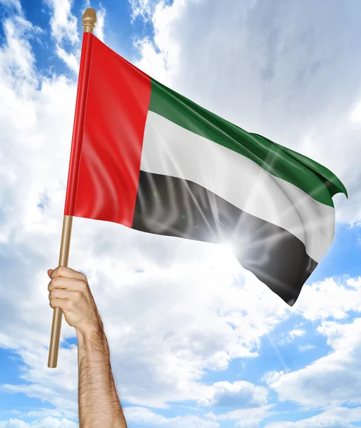 Iemands hand houden van de nationale vlag van Emiraten en het zwaaien in de lucht, 3D-rendering — Stockfoto