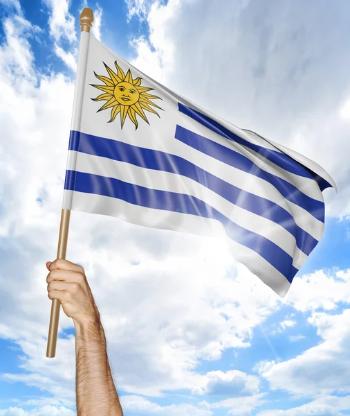 Mano de la persona sosteniendo la bandera nacional uruguaya y ondeándola en el cielo, representación 3D — Foto de Stock