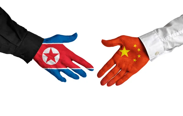 Les dirigeants nord-coréens et chinois se serrent la main sur un accord — Photo