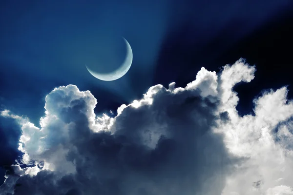 Crescent moon in a beautiful night sky with glowing clouds — Stock Photo, Image