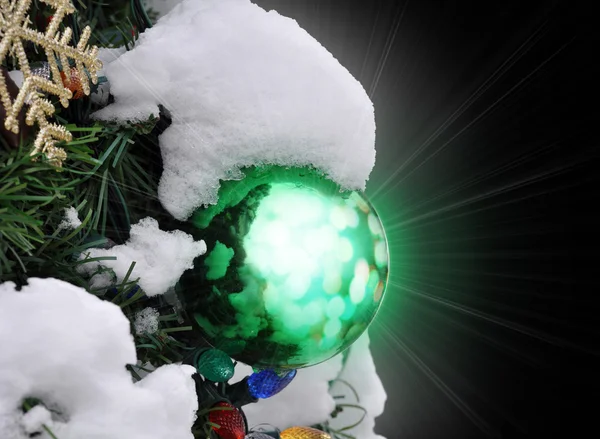 Shiny glass Christmas ornament covered in snow — Stock Photo, Image