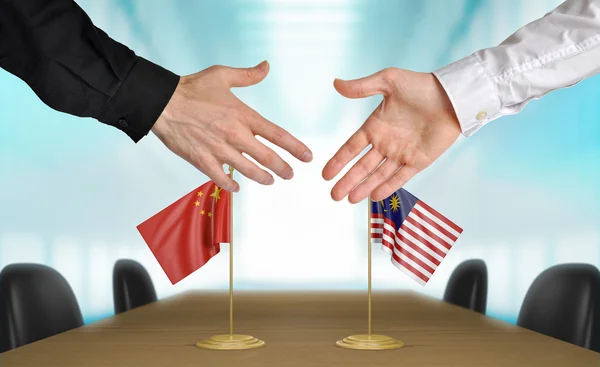 China and Malaysia diplomats agreeing on a deal — стокове фото