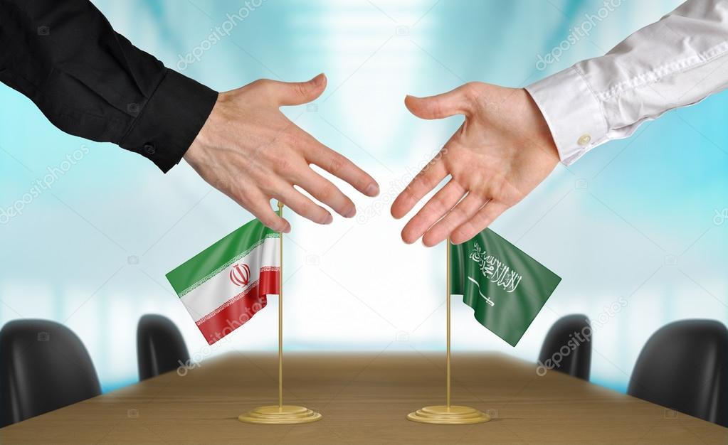 Iran and Saudi Arabia diplomats shaking hands to agree deal