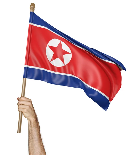 Ręką macha dumnie flagę narodową Korei Północnej — Zdjęcie stockowe