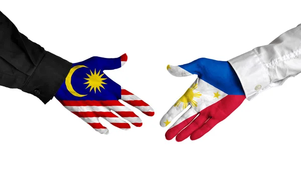Les dirigeants malaisiens et philippins se serrent la main sur un accord — Photo