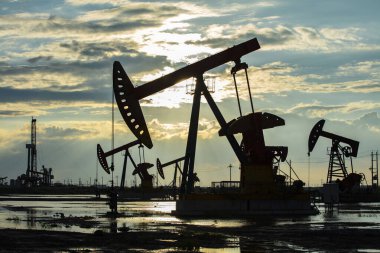 Petrol sahası, akşamları, petrol pompaları çalışıyor.