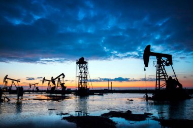 Petrol sahası, akşamları, petrol pompaları çalışıyor.