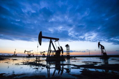 Petrol sahası, akşamları, petrol pompaları çalışıyor.