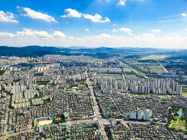 Gökyüzü, şehir merkezi ve küçük bir parkın görünümü.
