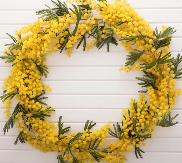 Mimoza çiçeği ahşap masa üzerinde çerçevesinden