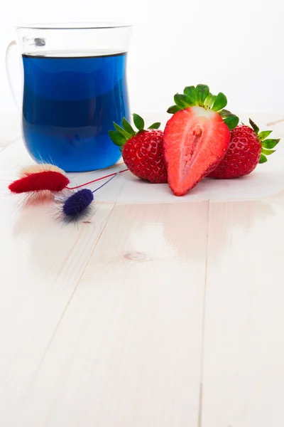 Blue Thai tea with strawberries and dry painted flowers — Stock Photo, Image