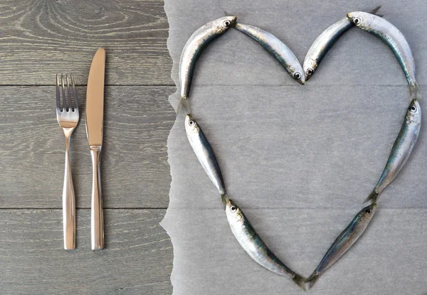 Sardine fraîche en forme de cœur et couverts — Photo