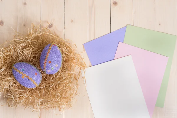 Два пасхальных яйца в гнезде и пустые карты разного цвета — стоковое фото