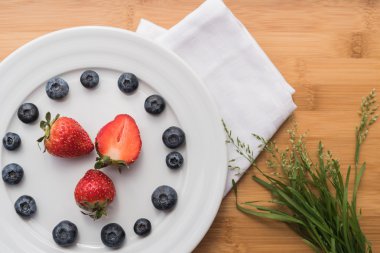 Çilek ve çim beyaz havlu üzerinde buket ile plaka