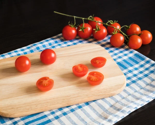 Tomates rojos cereza en tabla de cortar —  Fotos de Stock