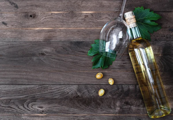 Botella de vino y uva fresca sobre fondo de madera — Foto de Stock