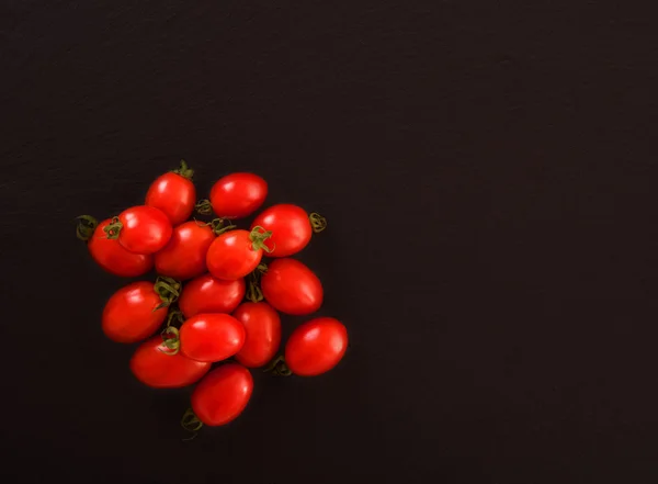 Grupo de tomates em placa preta — Fotografia de Stock