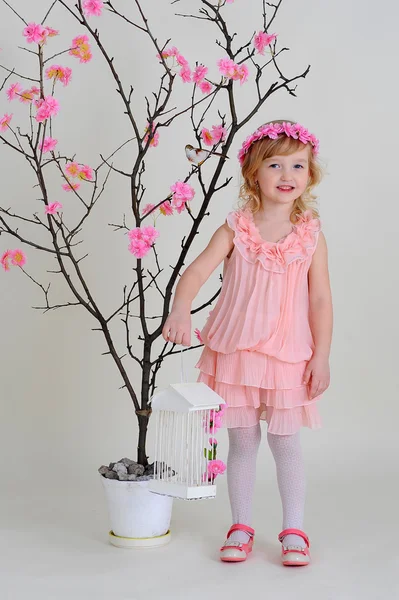 Girl in a pink wreath, with the cell in his hand and with a bird — Stock Photo, Image