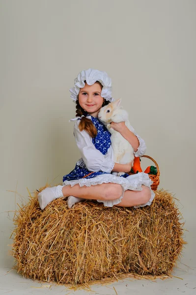 girl on hay hugging Easter Bunny.