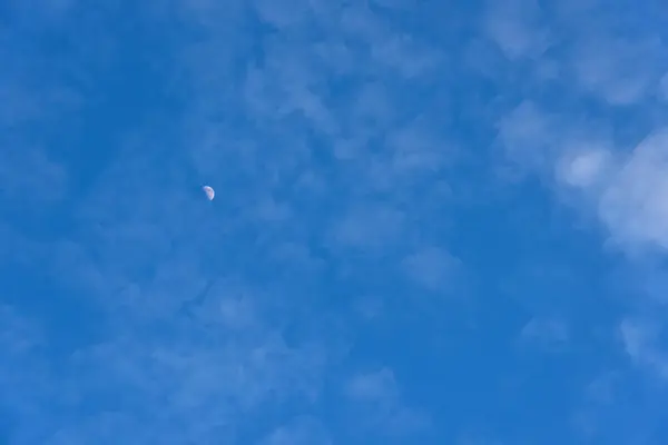 Daytime sky A small moon and clouds through. — Stock Photo, Image