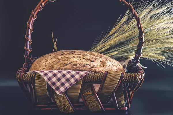 Vintage style: Homemade gluten-free and without yeast artisan bread in a wicker basket with ears of barley wrapped in a plaid napkin — Stock Photo, Image