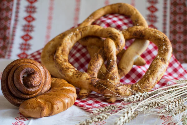 Homemade bread: pretzel bun Snail with poppy seeds and a croissant with jam — Stock Photo, Image