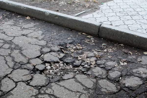 Broken asphalt. Broken road surface in the courtyard of a residential area.