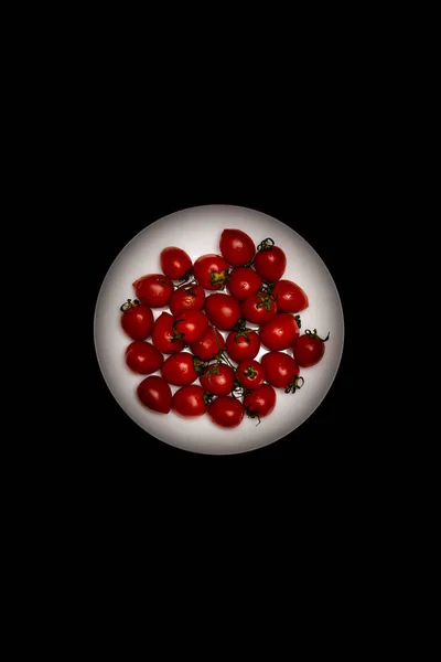 Pomidory Wiśniowe Białym Talerzu Czarnym Tle Widok Góry — Zdjęcie stockowe